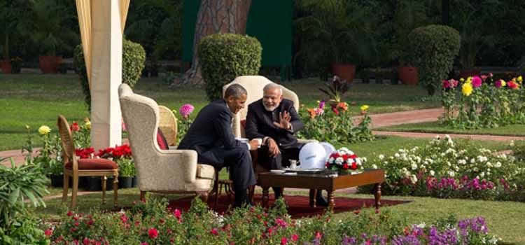 Two men sitting in a garden, talking. (Official White House Photo by Pete Souza)